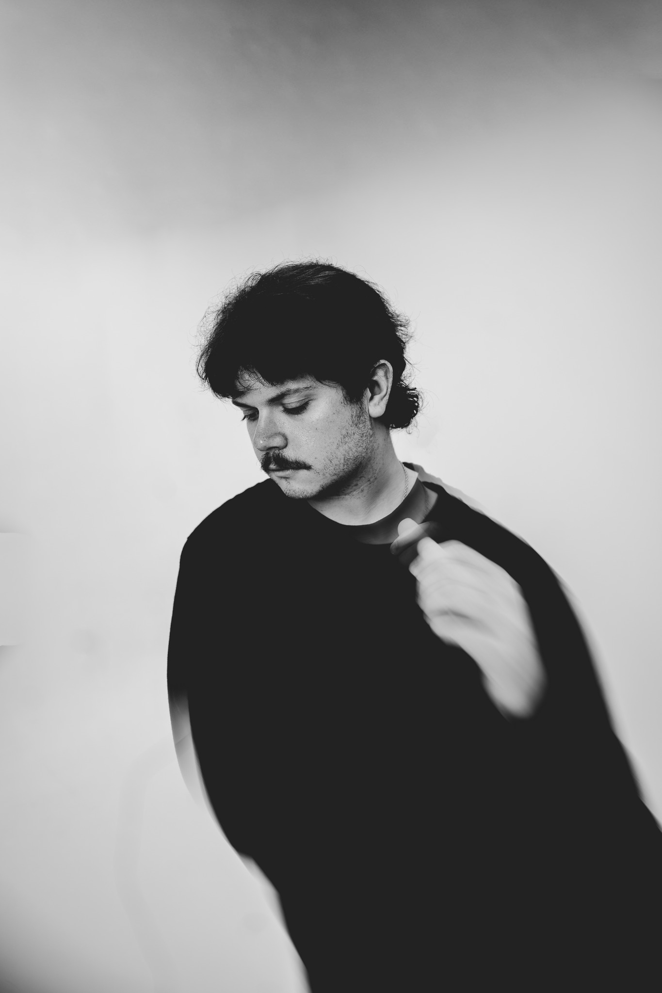 Black-and-white portrait of Tye Cristo looking downward